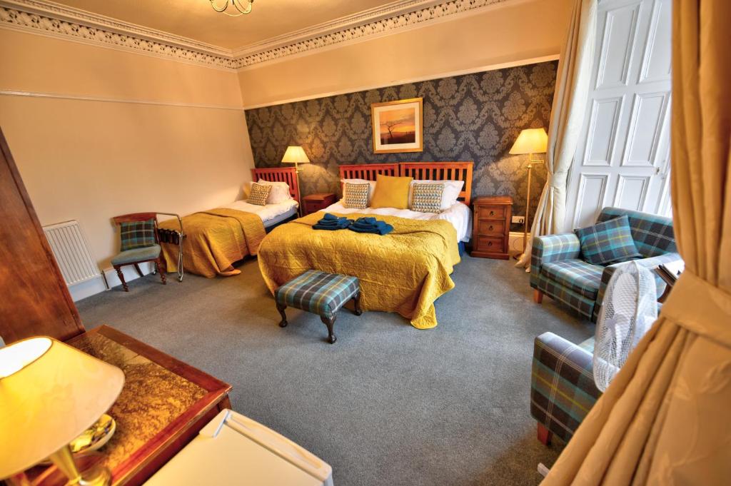 um quarto de hotel com duas camas e um sofá em Burnside Guest House em Ayr