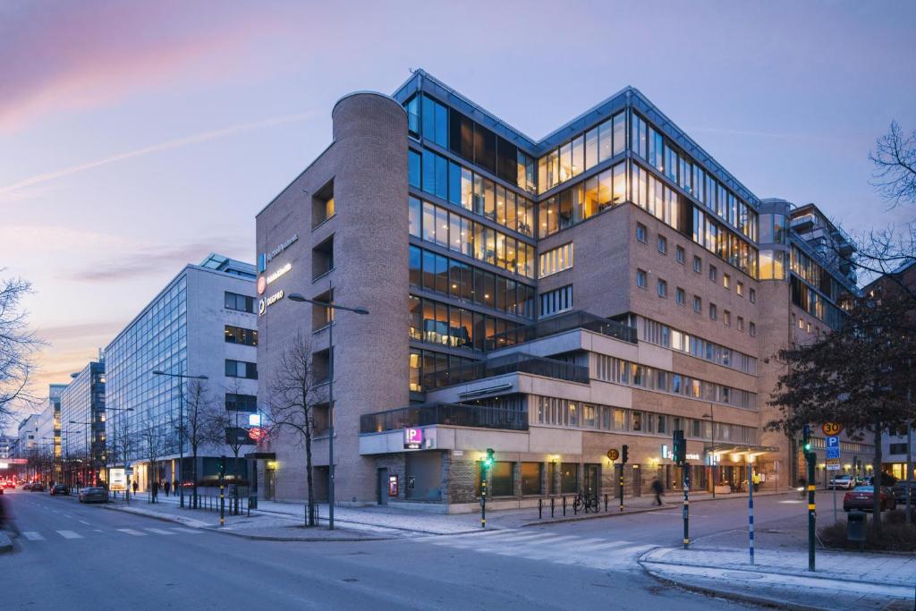 a large building on a city street at night at Sky Hotel Apartments, Stockholm in Stockholm