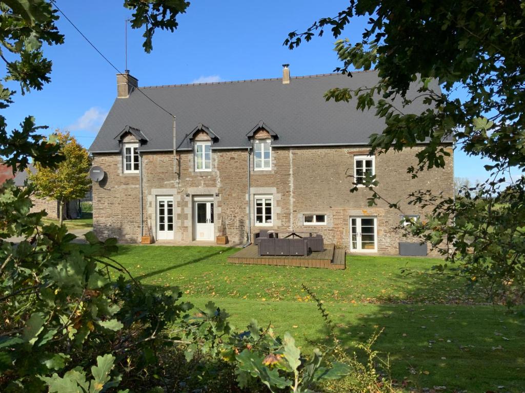 una gran casa de ladrillo con patio en Welcoming and peaceful bed and breakfast, en Fougerolles-du-Plessis
