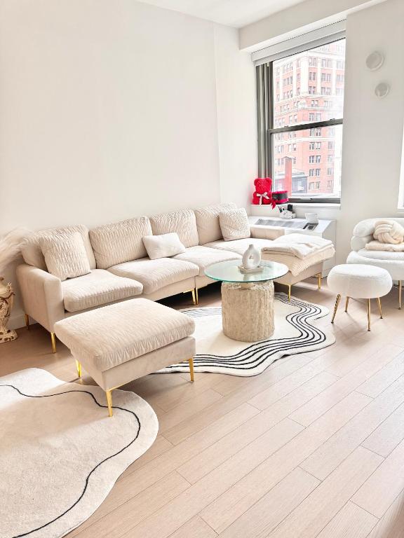 a living room with a couch and a table at Exquisite Urban Oasis: Luxury 1 Bedroom Retreat in Downtown Manhattan in New York