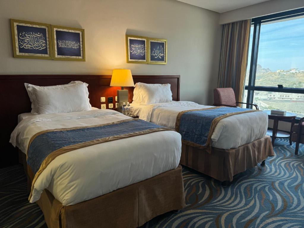 麥加的住宿－فندق الصفوة البرج الثالث 3 Al Safwah Hotel Third Tower，酒店客房设有两张床和窗户。