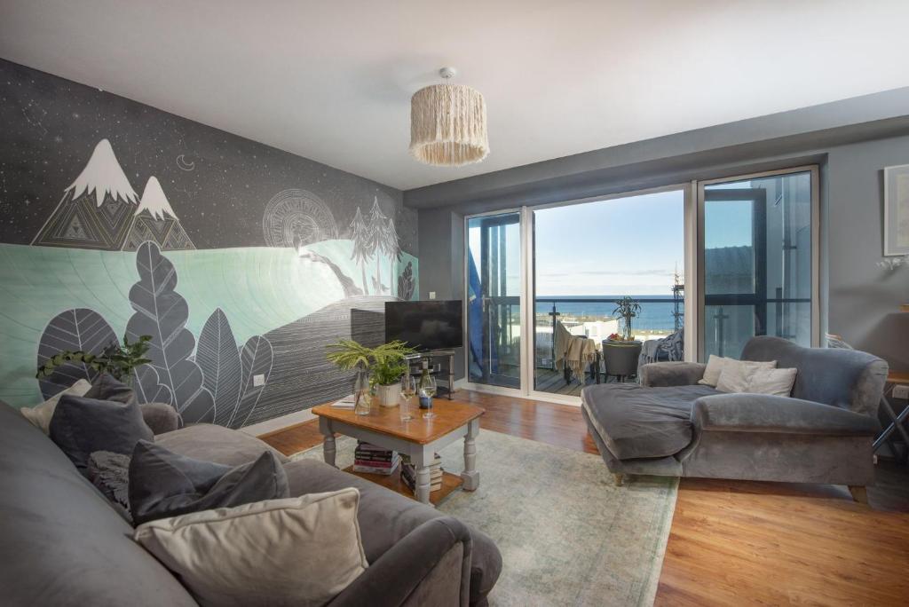 a living room with a couch and a table at Bathsheba, Ocean 1 in Newquay