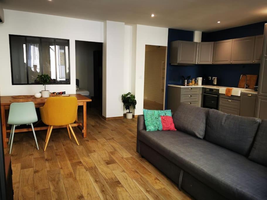 un salon avec un canapé et une table et une cuisine dans l'établissement Appartement*Loft*Centre historique de SARLAT, à Sarlat-la-Canéda