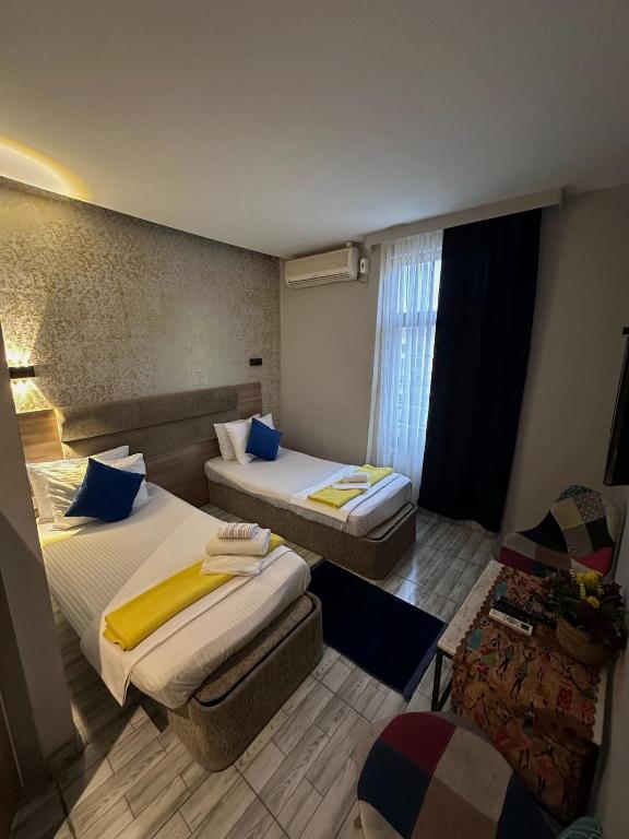 a hotel room with two beds and a chair at Mayata Pera in Istanbul