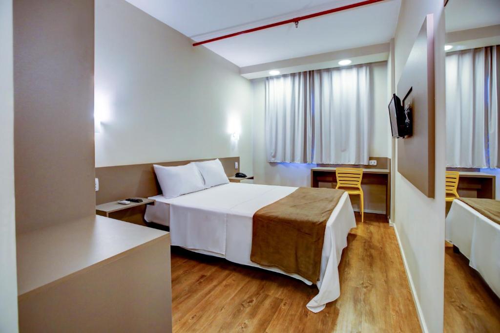 a hotel room with a bed and a desk at Blue Tree Towers Sorriso in Sorriso