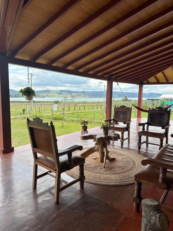a porch with chairs and a table and a table and a view at Casa Campestre Lago Calima in Calima