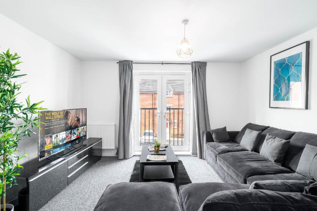 a living room with a couch and a tv at Luxury Selly Oak Apartment near QE & Uni - Secure Parking - 20CC in Birmingham