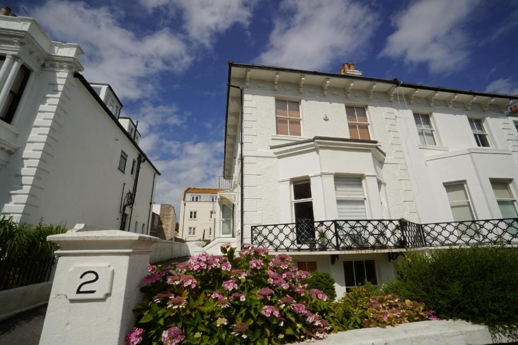 Un edificio blanco con flores delante. en Seafront Medina, en Brighton & Hove