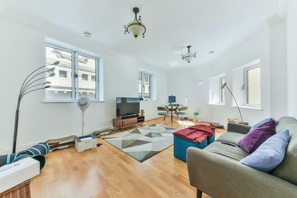 a living room with a couch and a table at Newly Furnished Penthouse Mayfair in London