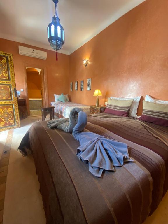 una camera con due letti e un lampadario a braccio di Riad Dar Teranga Hotel & Spa a Marrakech