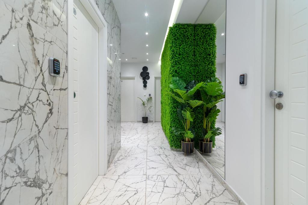 a hallway with a green wall with plants at Antares Luxury Rooms 2 in Split