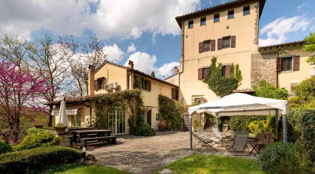 una casa con una mesa y una tienda en el patio en Villa Belcanto Mugello - Affitti Brevi Italia en Vicchio