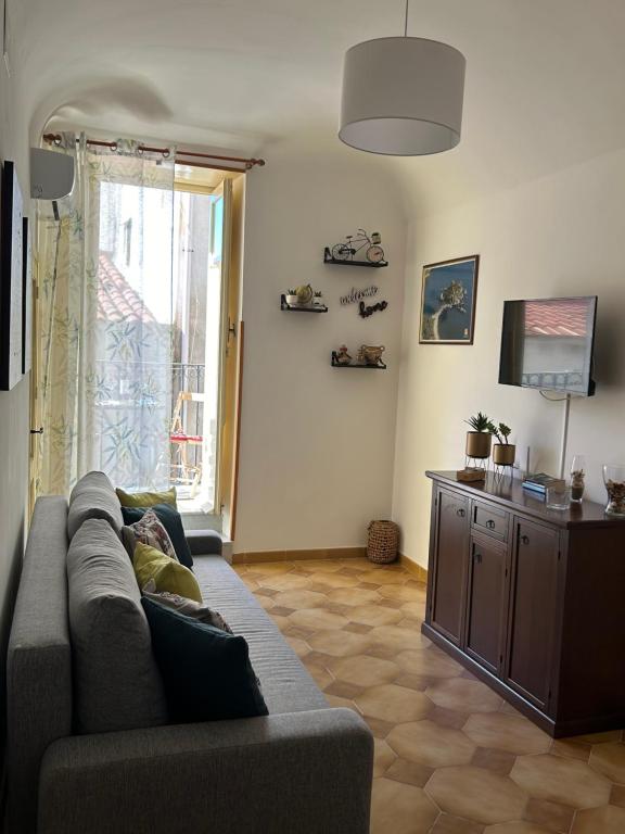 uma sala de estar com um sofá e uma televisão em L'Appartement dans les Venelles em Cefalù
