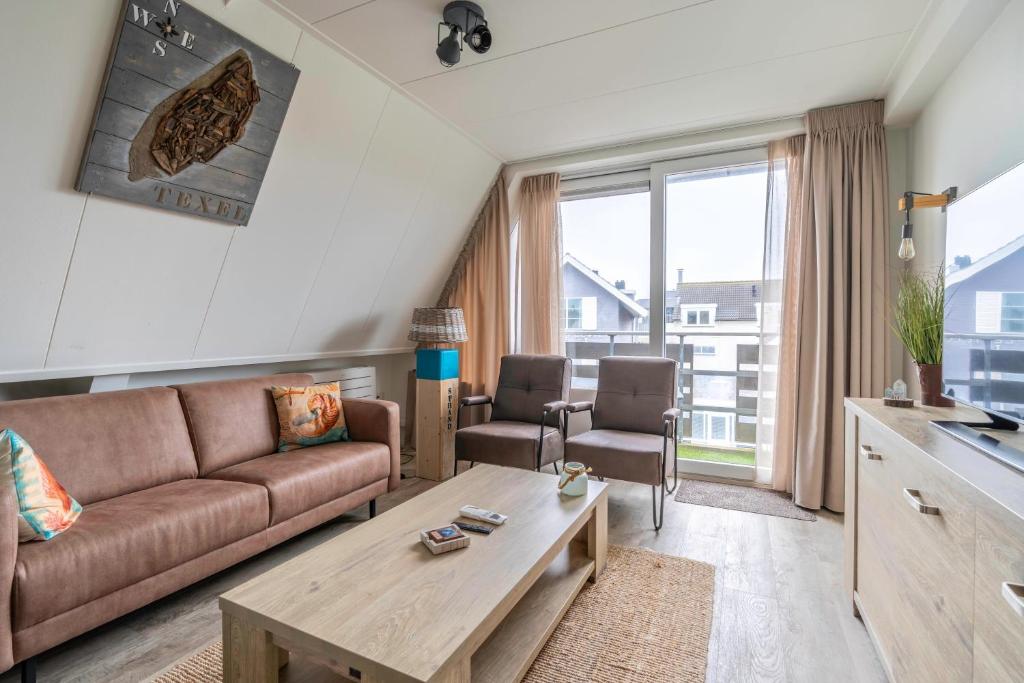 a living room with a couch and a table at Anna 222 in De Koog