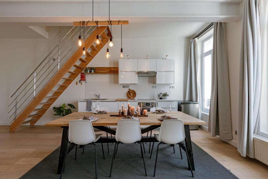 kuchnia i jadalnia z drewnianym stołem i krzesłami w obiekcie Apartment with large terrace in the city of Ghent w Gandawie