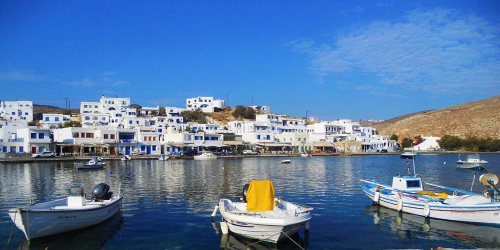 a group of boats docked in a harbor with buildings at Tinos Suites & Apartments with sea view in Agios Ioannis Tinos