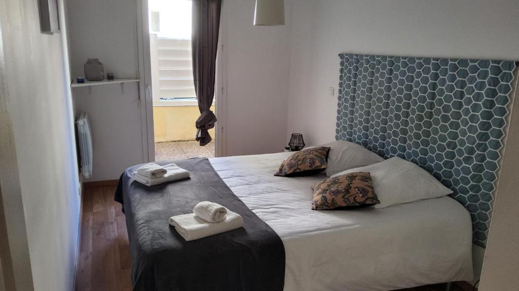 um quarto com uma cama com duas toalhas em Appartement, Lumières d'Arcachon em Arcachon