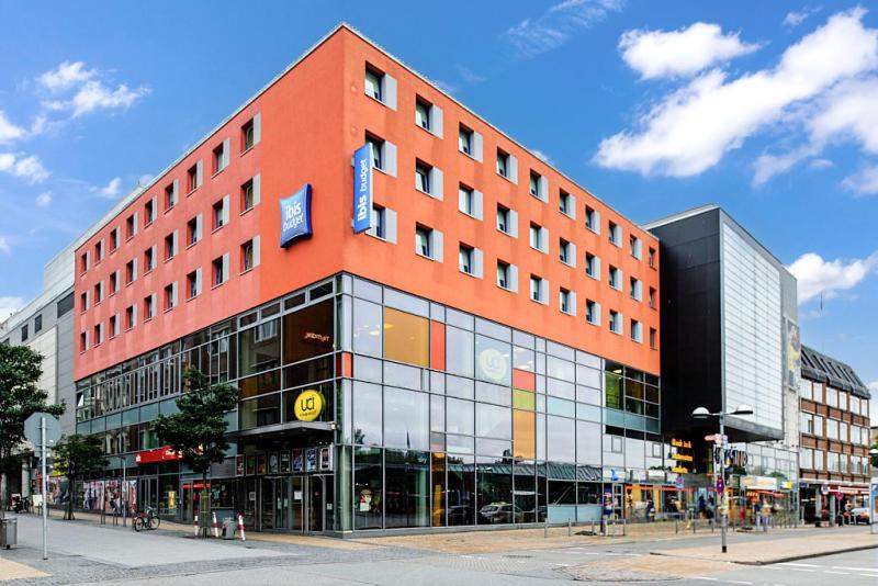 ein großes orangefarbenes Gebäude an einer Stadtstraße in der Unterkunft ibis budget Flensburg City in Flensburg