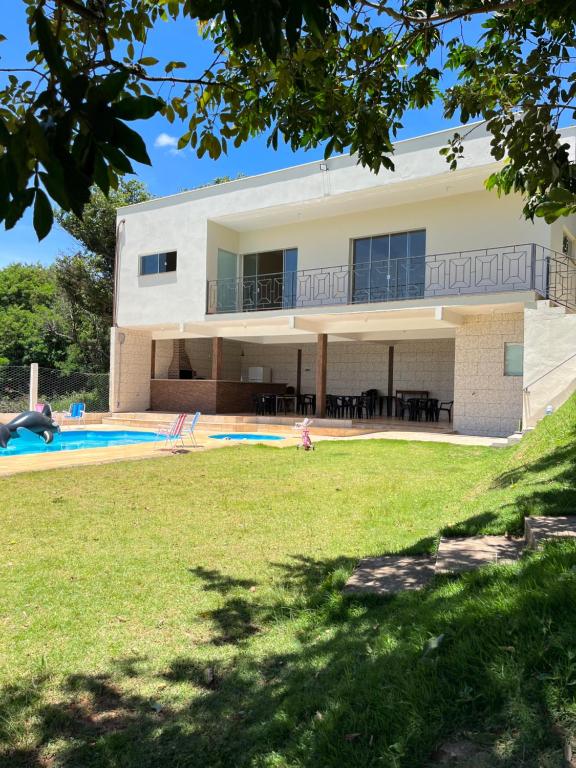 uma casa com uma piscina e um quintal em Chácara do André. em Serra Negra