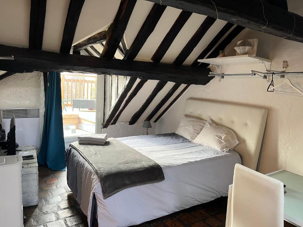 une chambre avec un lit dans une pièce avec une fenêtre dans l'établissement Rue du poirier, à Orléans