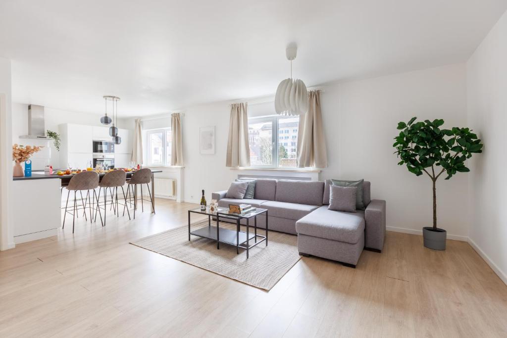ein Wohnzimmer mit einem Sofa und einem Tisch in der Unterkunft Sweet Inn - Michel Ange in Brüssel