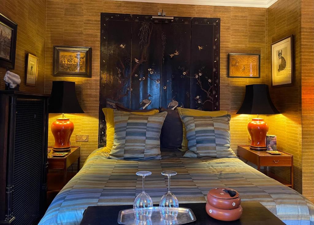 sypialnia z łóżkiem z 2 kieliszkami do wina w obiekcie Toute Une Histoire w mieście Veneux-les-Sablons