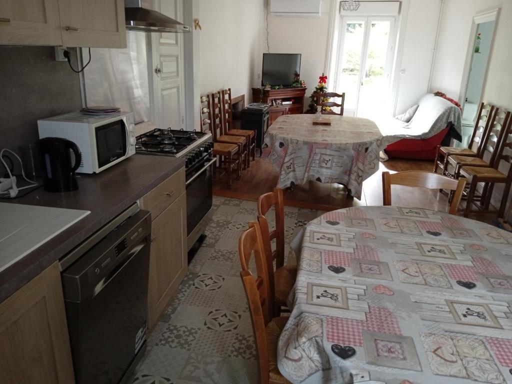 a kitchen with a table with a microwave and a table with a tableablish at Gite au sein du Parc des Volcans d&#39;Auvergne, tous commerces à pied in Neussargues-Moissac