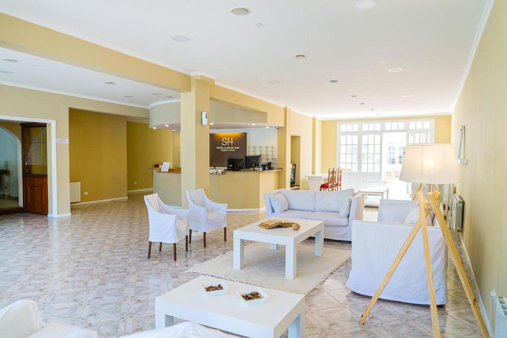 un salon avec des meubles blancs et une table dans l'établissement SH Hotel & Spa de Mar Samay Huasi, à Puerto Madryn