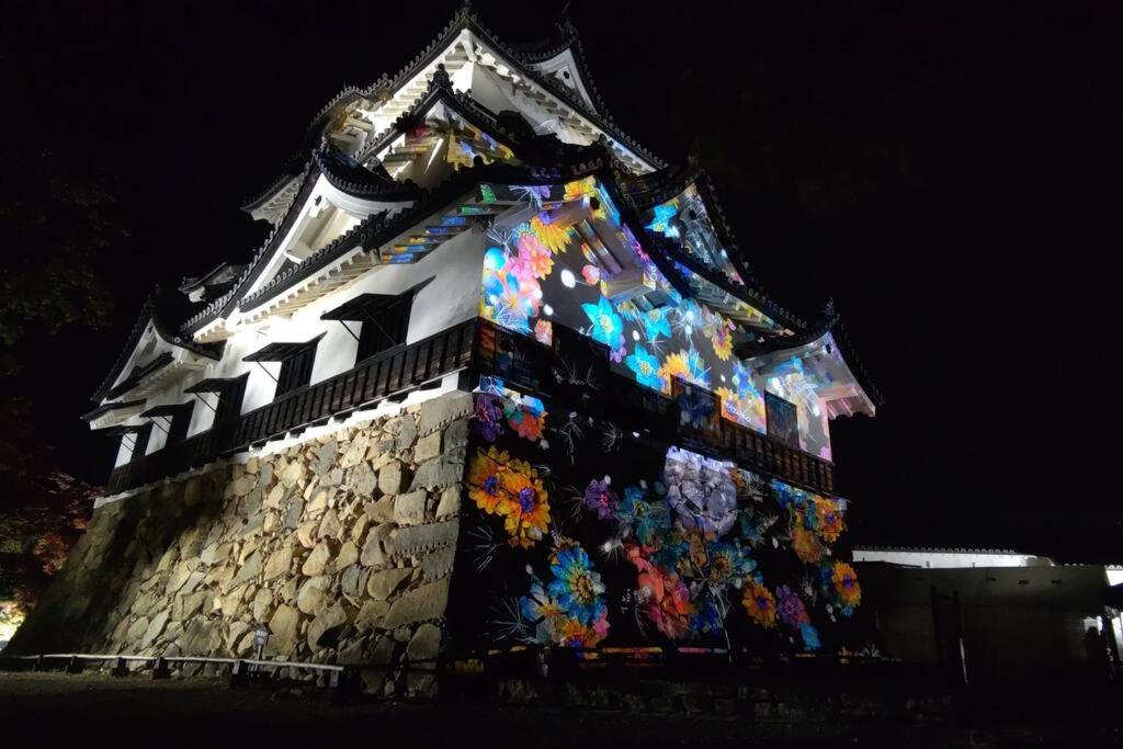 a building with a painting on it at night at Villa Hikone Castle in Hikone