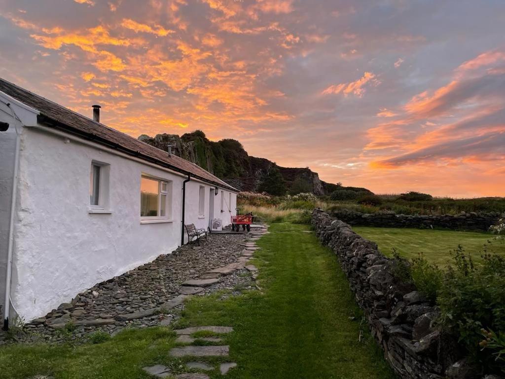 a house with a stone path next to a building at Easdale Cottage in Oban