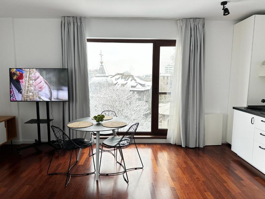 a kitchen with a table and chairs in front of a window at Central Haven Studio in Bucharest