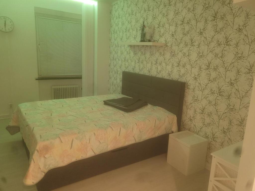 Garsoniera في مالمو: غرفة نوم بسرير في غرفة مع ورق جدران
