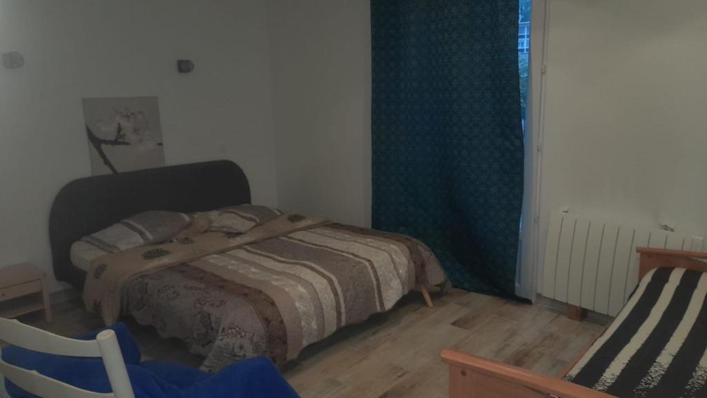 una piccola camera con letto e sedia di 5 Rue Adeline a Pierrefitte-sur-Seine