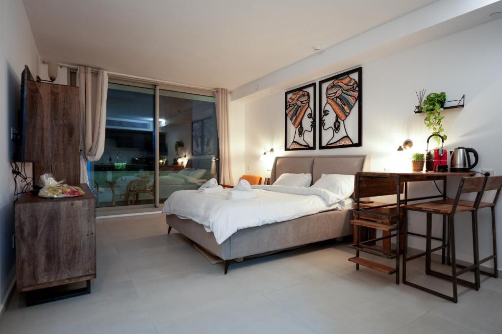 a bedroom with a bed and a desk in it at Sea side 87 Sweet Me Eilat אילת in Eilat