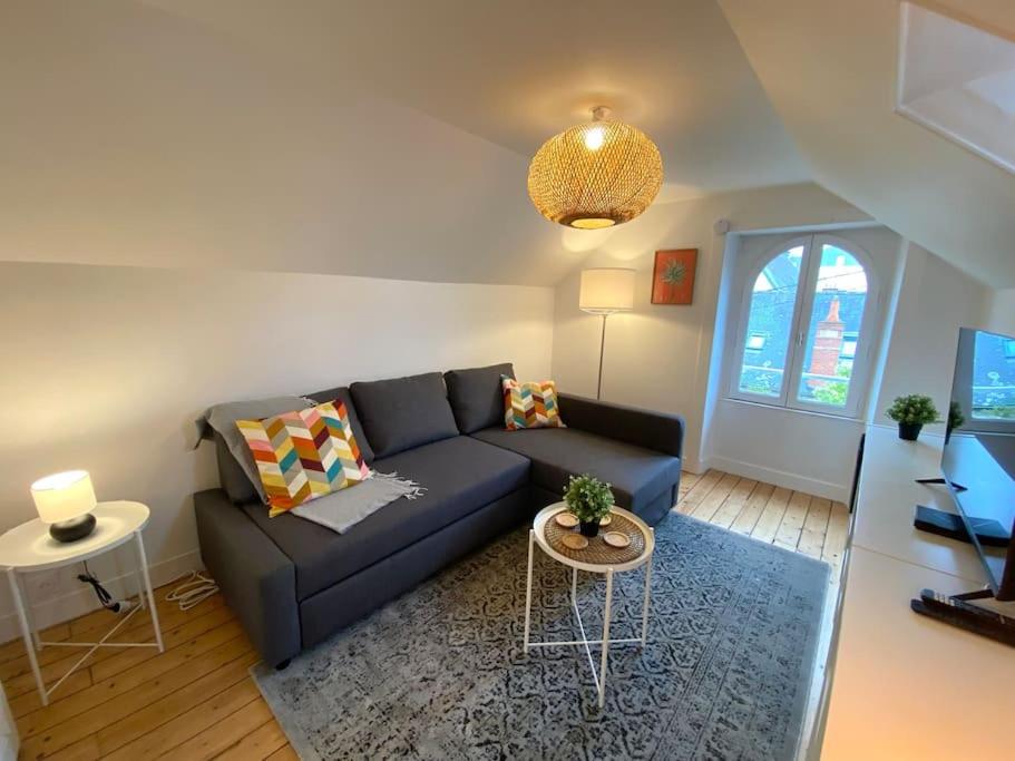 un soggiorno con un divano blu e un tavolo di Le Thabor - T3 proche Centre Rennes a Rennes