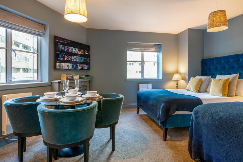 um quarto de hotel com uma cama, uma mesa e cadeiras em Silcox House Bath em Bath