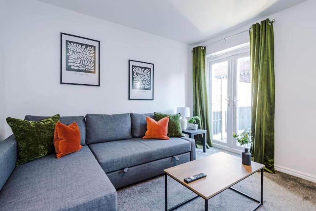 a living room with a blue couch with orange pillows at The Olive Suite in Clock Face