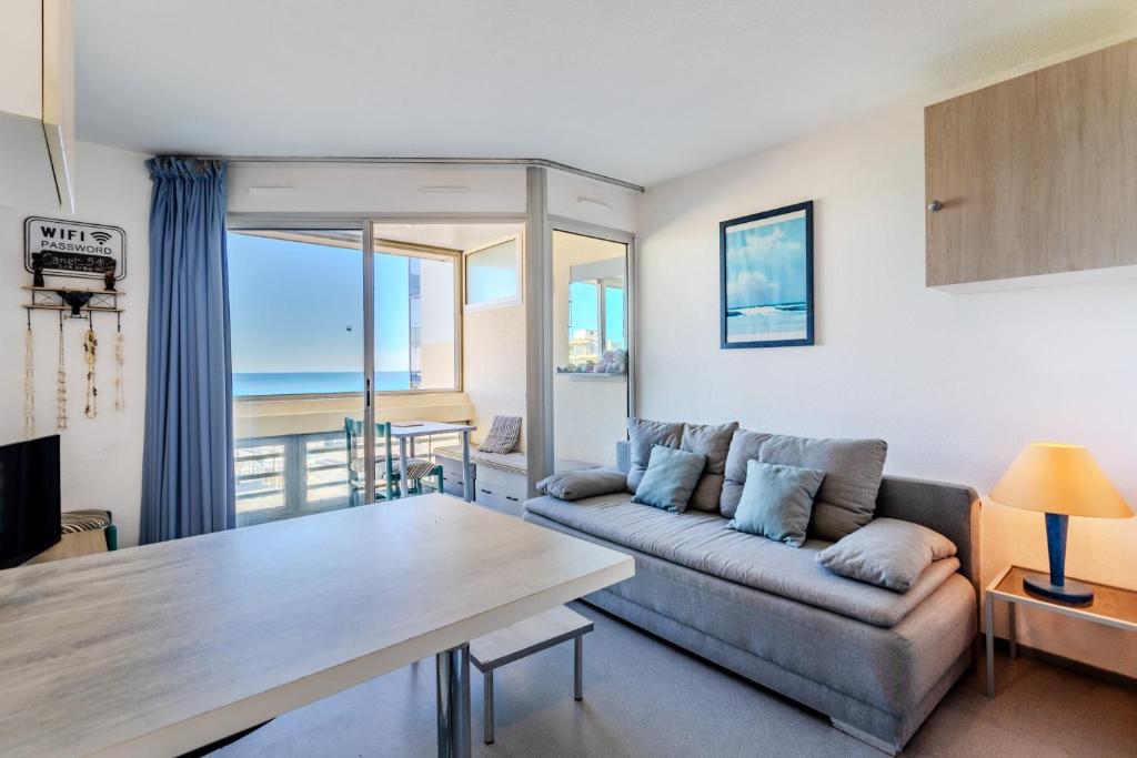 a living room with a couch and a table at Studio vue mer in Canet-en-Roussillon