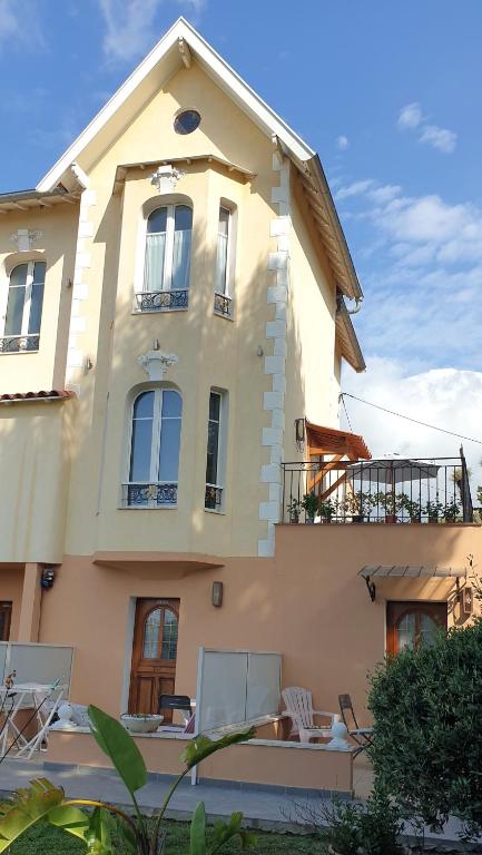 une grande maison avec des chaises devant dans l'établissement GRAND Studio meublé-Juan Pins-Logt 4, à Antibes