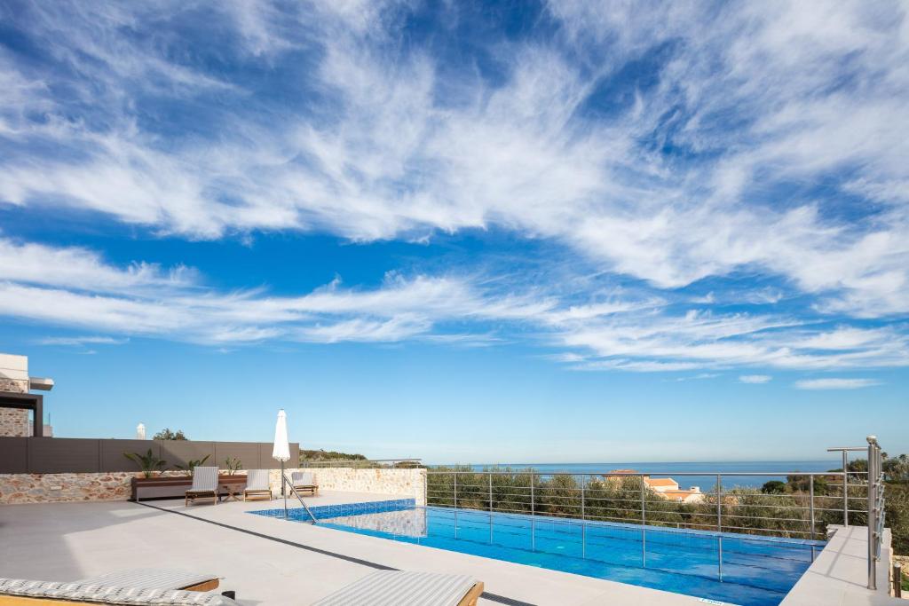 a swimming pool with a view of the ocean at Oinolithos Luxury Villas in Kalamaki Chanion