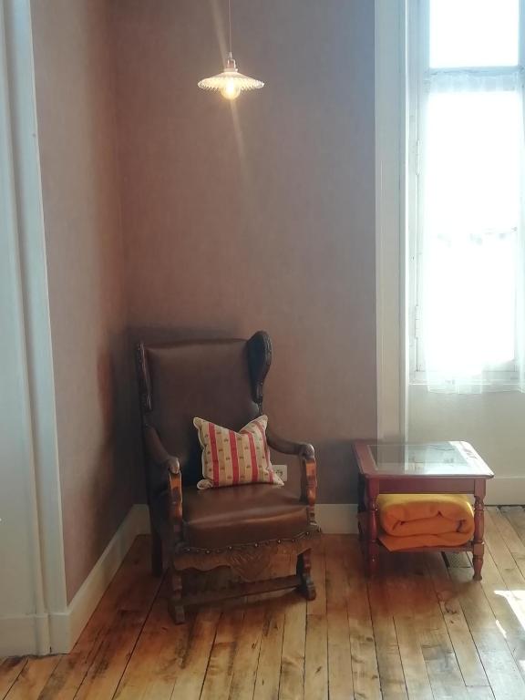 a chair with a pillow and a table in a room at Thunder Roadhouse in La Mothe-Saint-Héray