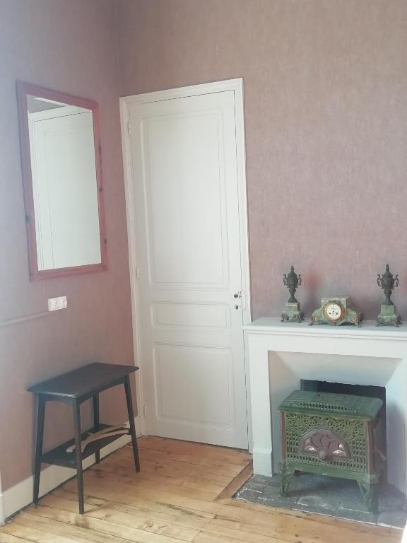a room with a fireplace and a table and a door at Thunder Roadhouse in La Mothe-Saint-Héray
