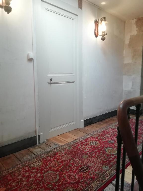 a white door in a room with a red rug at Thunder Roadhouse in La Mothe-Saint-Héray