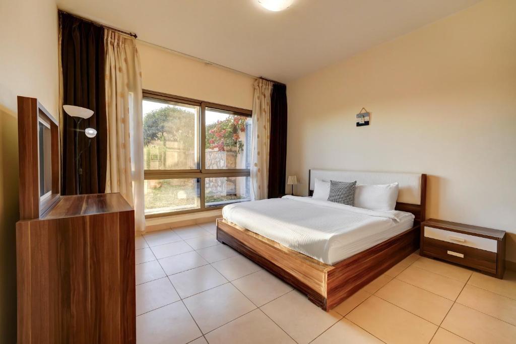 1 dormitorio con cama y ventana grande en Family Sweet - Apartment in Tala Bay Aqaba, en Al Burj