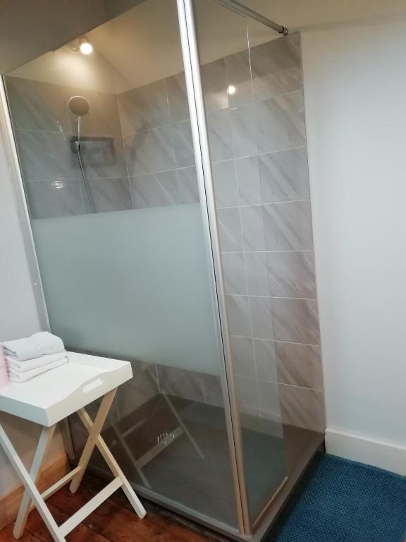 a shower with a glass door next to a stool at Thunder Roadhouse in La Mothe-Saint-Héray
