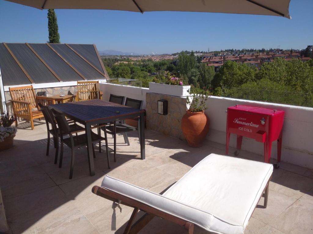 a patio with a table and chairs on a roof at Atico España in Las Rozas de Madrid