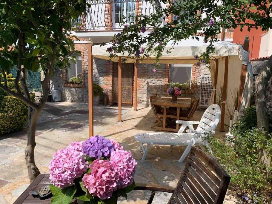 a patio with a table and flowers on a bench at Apartamento con jardín in Santander