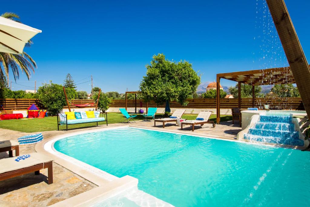duży basen z krzesłami i stołem w obiekcie Aestas Residence, Refined Summer Retreat with Pool, By ThinkVilla w mieście Prínos