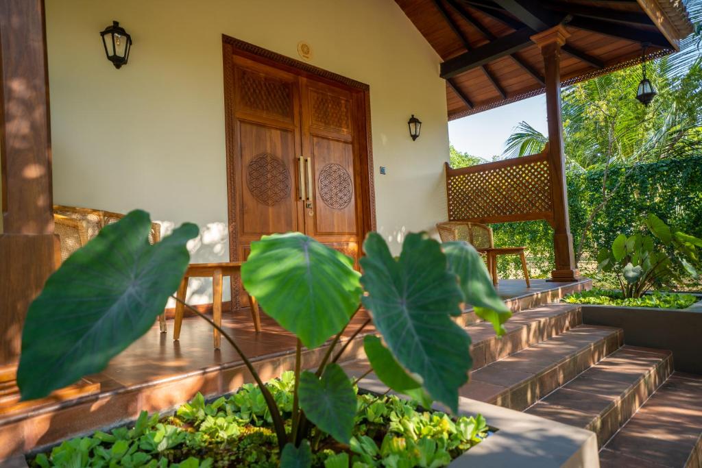un porche de una casa con escaleras y una puerta de madera en Omkara Rekawa, en Tangalle