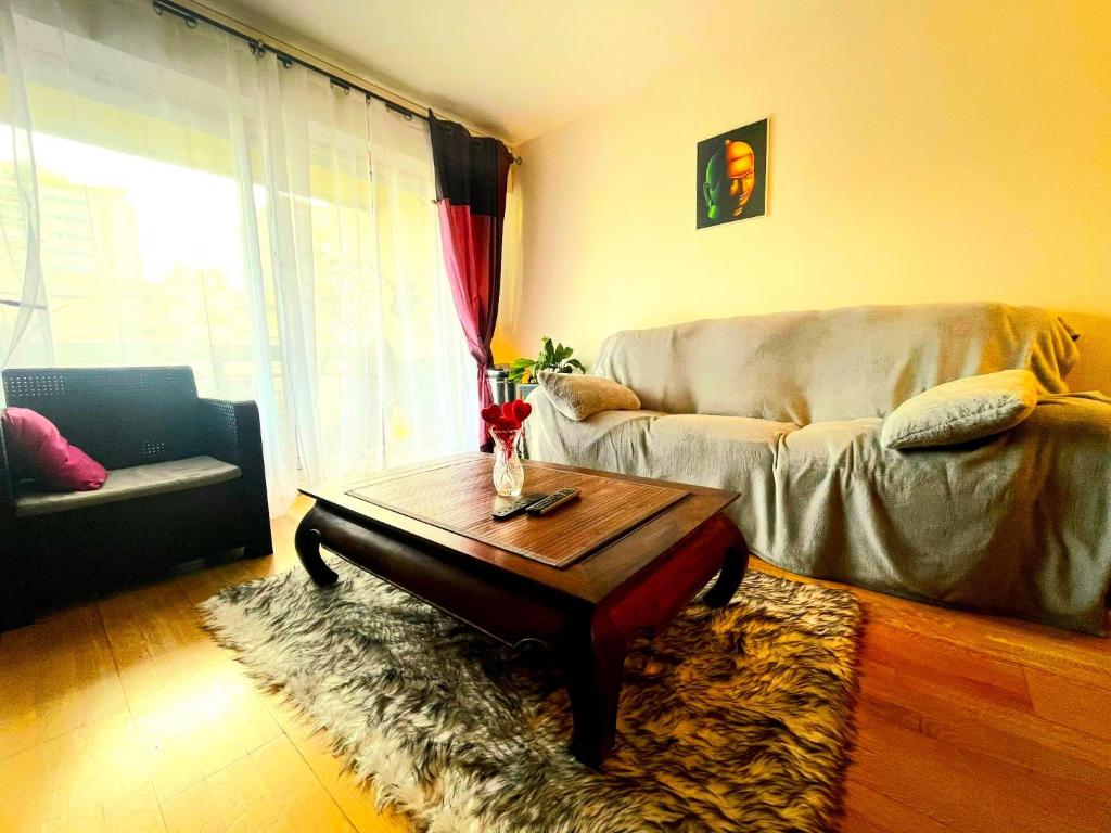 un salon avec un canapé et une table basse dans l'établissement Appartement 3 pièces 70m² Courbevoie Paris La Défense avec Balcon, à Courbevoie